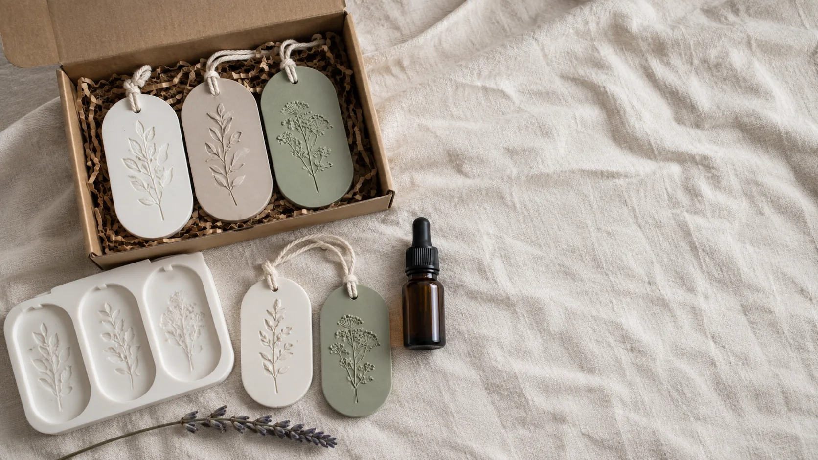 A boxed set of scented aroma stones beside the silicone mould, a bottle of fragrance oil and two hanging stones